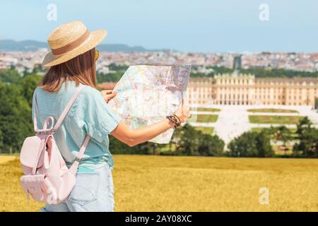 20 July 2019, Vienna, Austria: Happy young asian woman travel in Schoenbrunn royal palace garden. Searching right location on tourist map Stock Photo