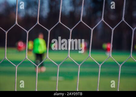 Soccer concept photo, football net, players in background Stock Photo