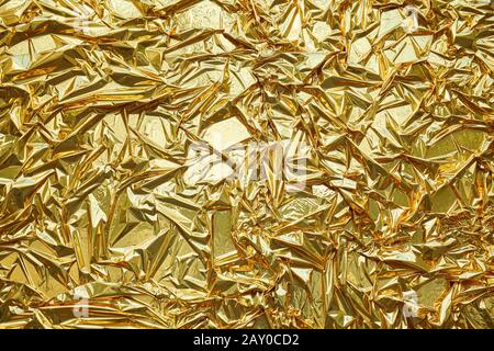 Crumpled, gold metallic foil texture background Stock Photo