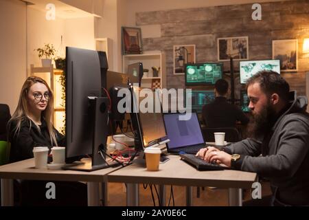 Team of dangerous hackers planning a big cyber attack on big corporates around the world. Female hacker. Stock Photo