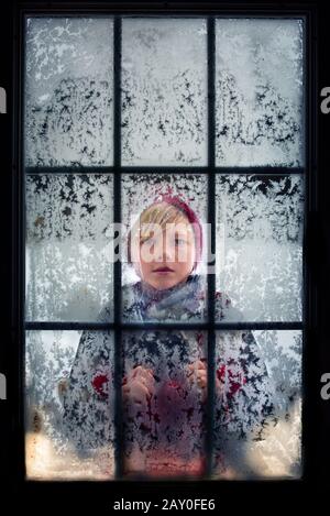 Boy looking through a frosty window, USA Stock Photo