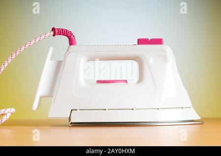 Modern electric iron against the colorful background Stock Photo