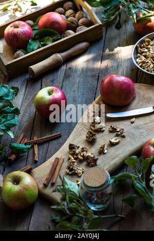 Apples, walnuts and spice arrangement on a wooden table Stock Photo