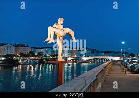23 July 2019, Lyon, France: Two men statue named The Weight of Oneself, on a bank of Saone river during evening time Stock Photo