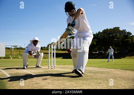 Cricket player shooting in the ball Stock Photo