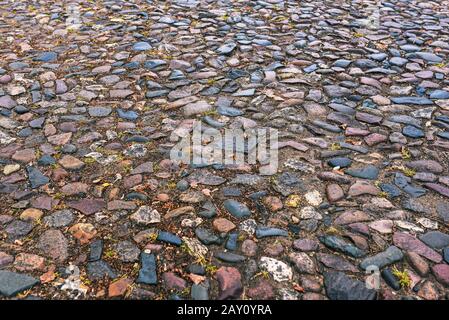 Cobblestone pavement texture. Panorama of the road from stone blocks. Old City. Stock Photo