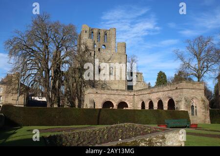 Remains of the cloisters at Keslo Abbey with the ruins of the West Tower of the Abbey in the background seen from the adjacent War Memorial garden. Stock Photo