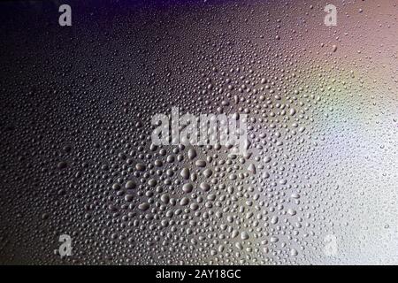 Drops of morning dew on the glass. Background image with sunlight. Stock Photo