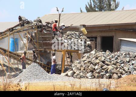 Kampala, Uganda - February 1, 2015: Male workers are working in harsh conditions at an African quarry doing manual work. Stock Photo