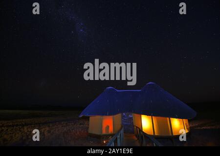 Huts, chalets of Sossus Dune Lodge at night with milky rhinestones Stock Photo