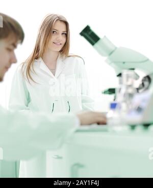 Two female scientists working at the laboratory with microscope Stock Photo