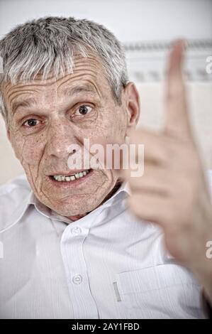 Angry senior man pointing his finger Stock Photo