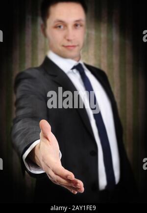 Successful young man extending hand to shake Stock Photo