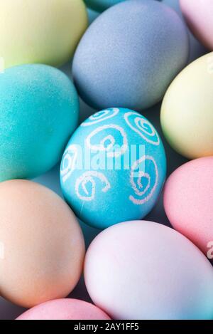 Colorful Easter eggs dyed by colored water isolated on a pale blue background, design concept of Easter holiday activity, close up, copy space. Stock Photo