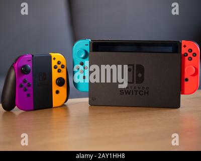 UK - Feb 2020: Nintendo Switch neon joy con controllers and portable console on table Stock Photo