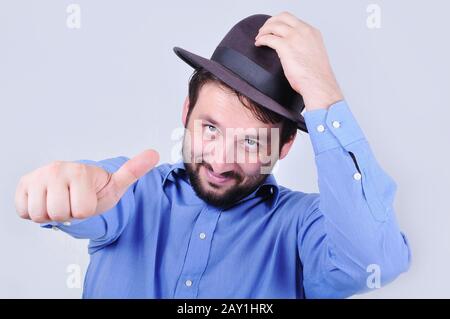 Young man with hat and pointing with his thumb up Stock Photo
