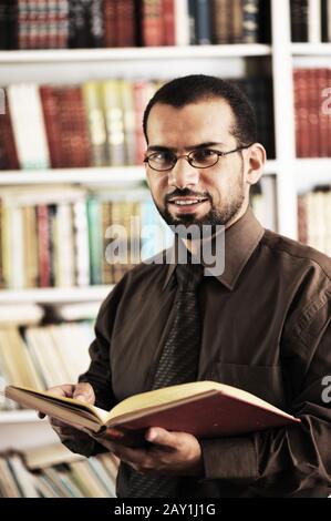 Young man reading book in library Stock Photo