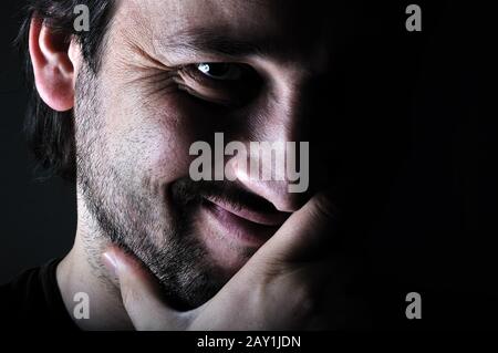 Young man smiling in the dark Stock Photo