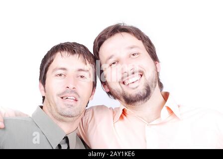 Two men in shirts are smiling and huging each other Stock Photo