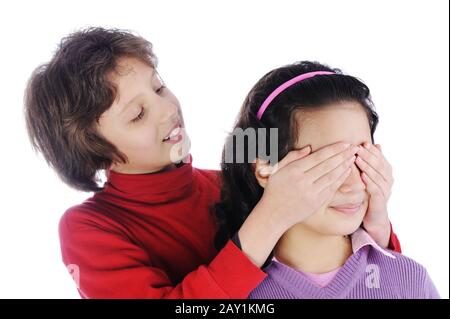Girl covering a girls eyes to see if she can guess who is behind her Stock Photo