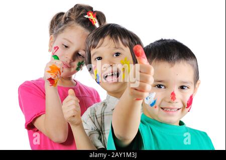 Messy children with paint on their hands and faces with thumbs up Stock Photo