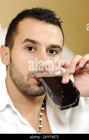 Young attractive man drinking cherry juice Stock Photo