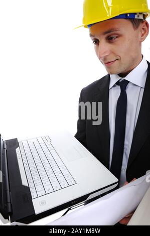 Construction engineer using his laptop computer and blueprints in the job Stock Photo