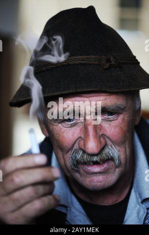 Closeup Artistic Photo of Aged Man With  Grey Mustache Smoking Cigarette Stock Photo