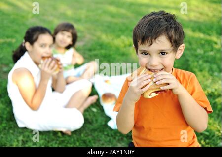 Small group of children in nature eating snacks together, sandwiches, bread Stock Photo
