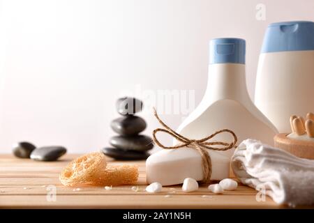 Massage and bath products on wooden table and massage stones with wood background. Front view. Horizontal composition. Stock Photo