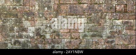 Panorama - Old, heavily weathered wall made of red sandstone Stock Photo