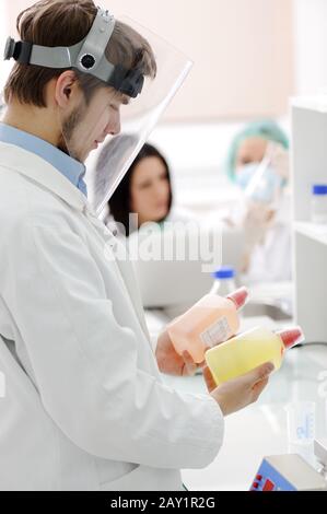group of the students working at the laboratory with liquids in bottles Stock Photo