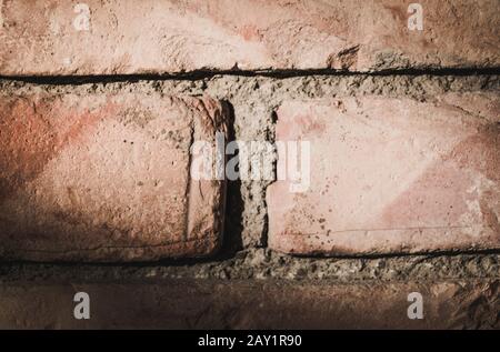 Close up of a brick wall with harsh light from the upper left Stock Photo