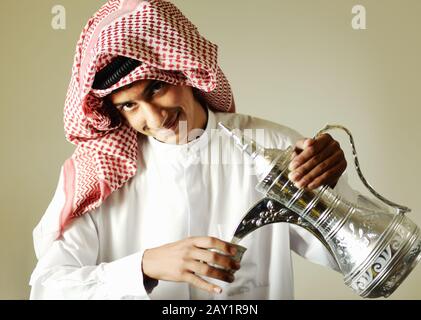 Arabic young man pouring a traditional coffee Stock Photo