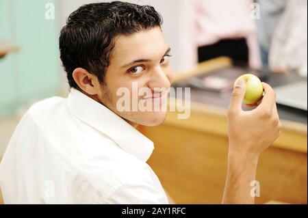 Student in collage with an apple in hand smiling Stock Photo