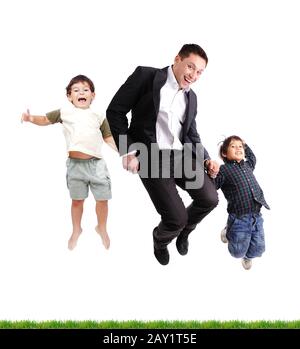 Father and sons  jumping over green grass Stock Photo