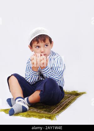 Little muslim boy is praying on traditional way Stock Photo