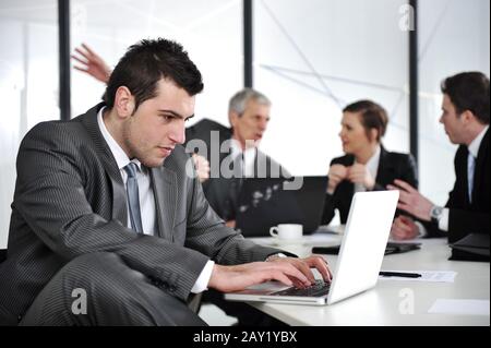 Businessman in business ambience working on laptop Stock Photo