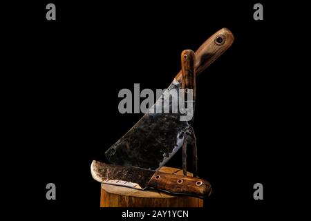 Rustic butcher meat knife, cleaver and fork on black background Stock Photo