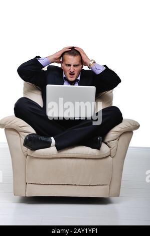 Businessman having headache while sitting in front of his laptop Stock Photo