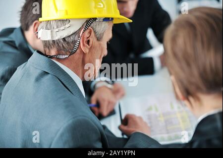 Senior executive showing future construction plans to his colleagues Stock Photo