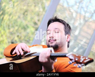 Man playing guitar and relaxing at home Stock Photo
