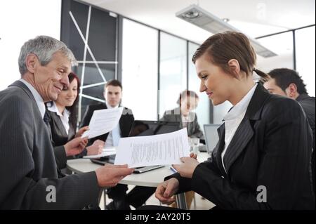 Young businesswoman in business meeting at office with colleagues in background Stock Photo