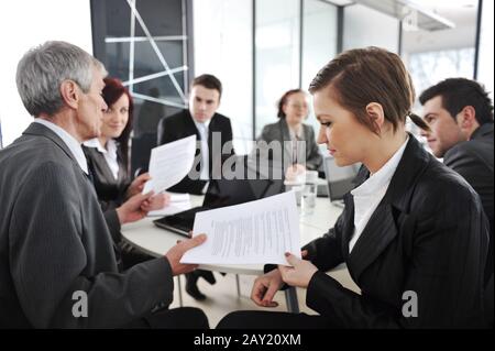 Young businesswoman in business meeting at office with colleagues in background Stock Photo