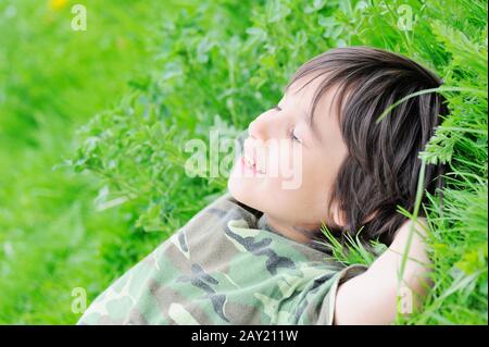 Cute little boy laying on grass Stock Photo