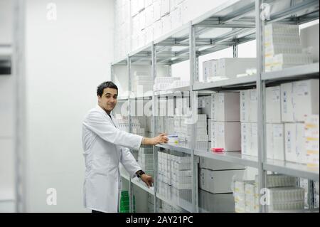 Worker putting boxes together on shelves in modern warehouse Stock Photo