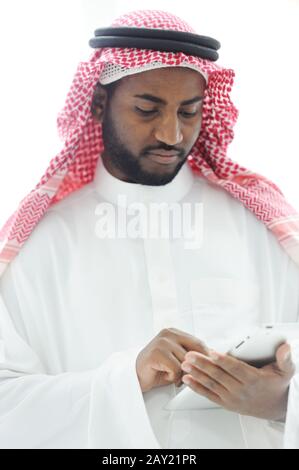 Middle eastern man with gulf clothes using tablet at office Stock Photo