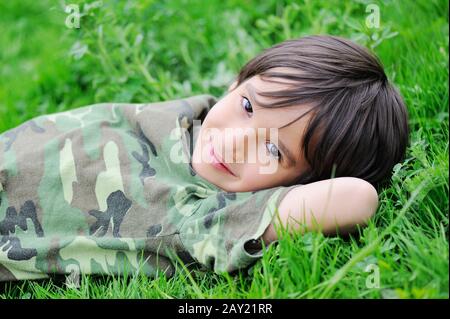 Cute little kid laying on grass Stock Photo