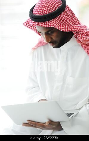 Black Arabic man working on laptop Stock Photo