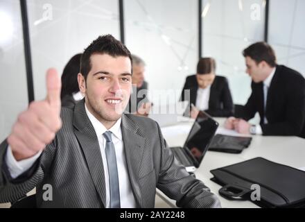 Portrait of young businessman in the office with thumb up Stock Photo